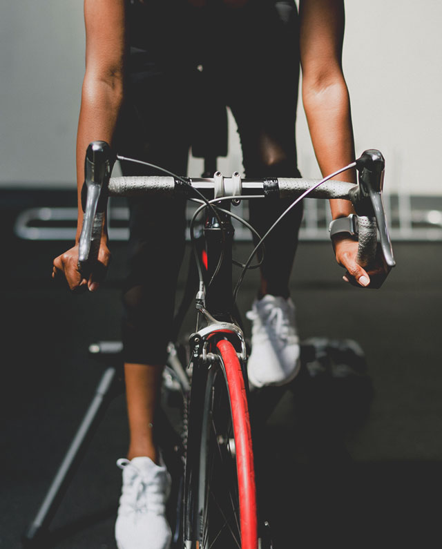 Eine Frau fährt Cardio-Rad im Fitnessstudio